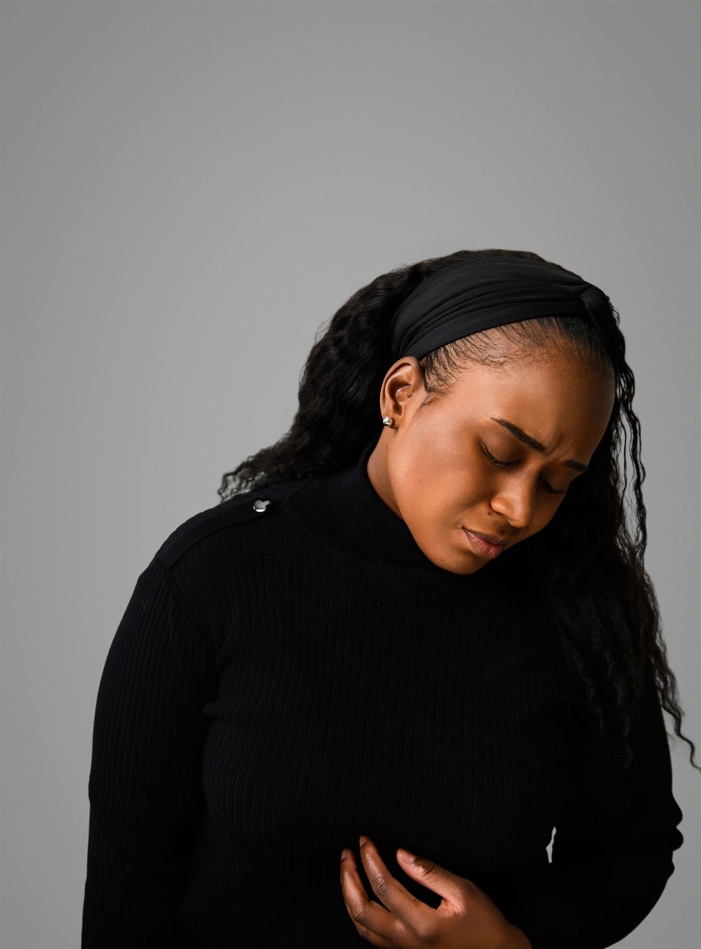 Shalanda Shaw, head bowed, against a grey backdrop